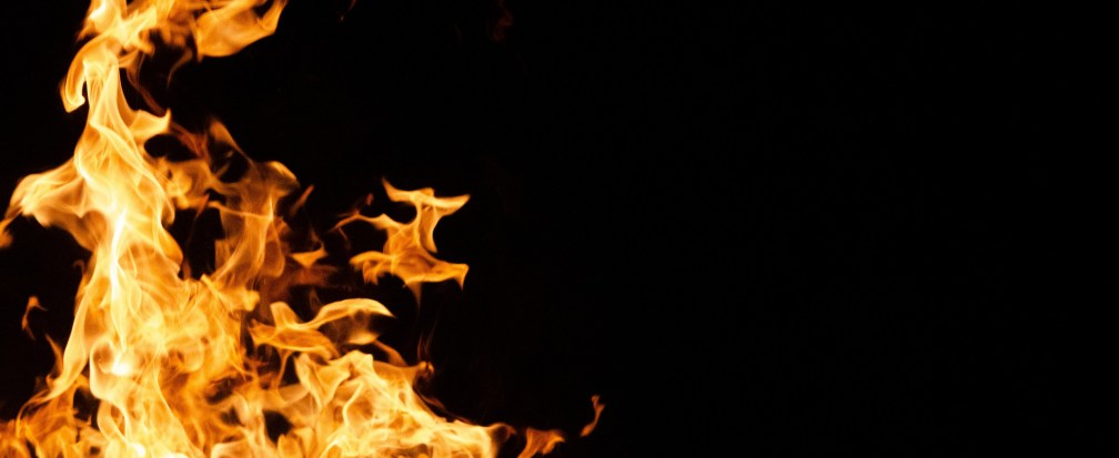An orange and red flame rises against a black background.